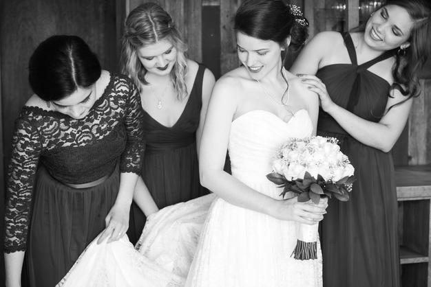 bride with bridesmaids fluffing gown