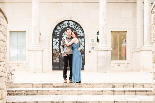 Engaged couple in front of white building