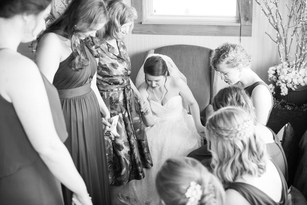 bride praying with bridesmaids before ceremony