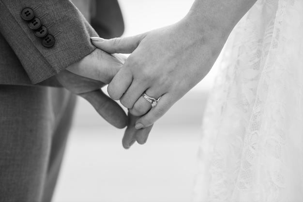 black and white image of newlyweds holding hands