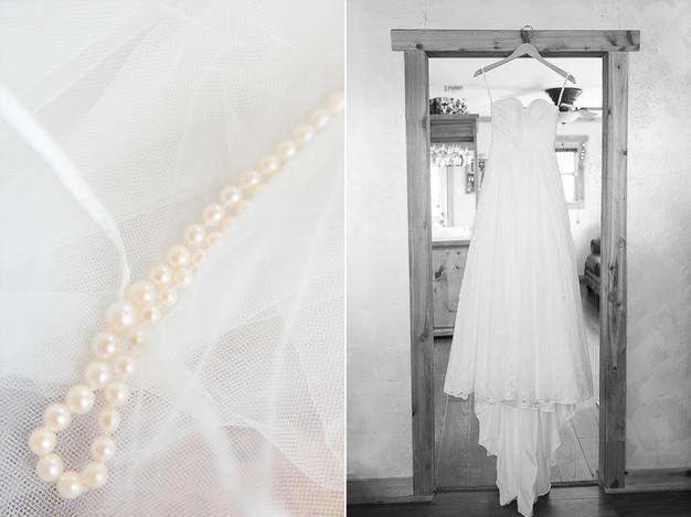 wedding pearls and lace gown hanging in doorway
