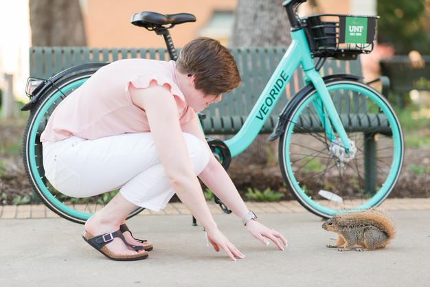 woman by teal bike and squirrel