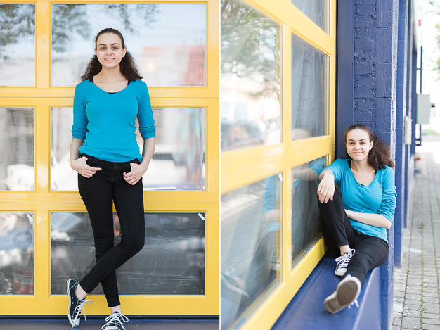 High school senior girl next to blue and yellow windows in Dallas