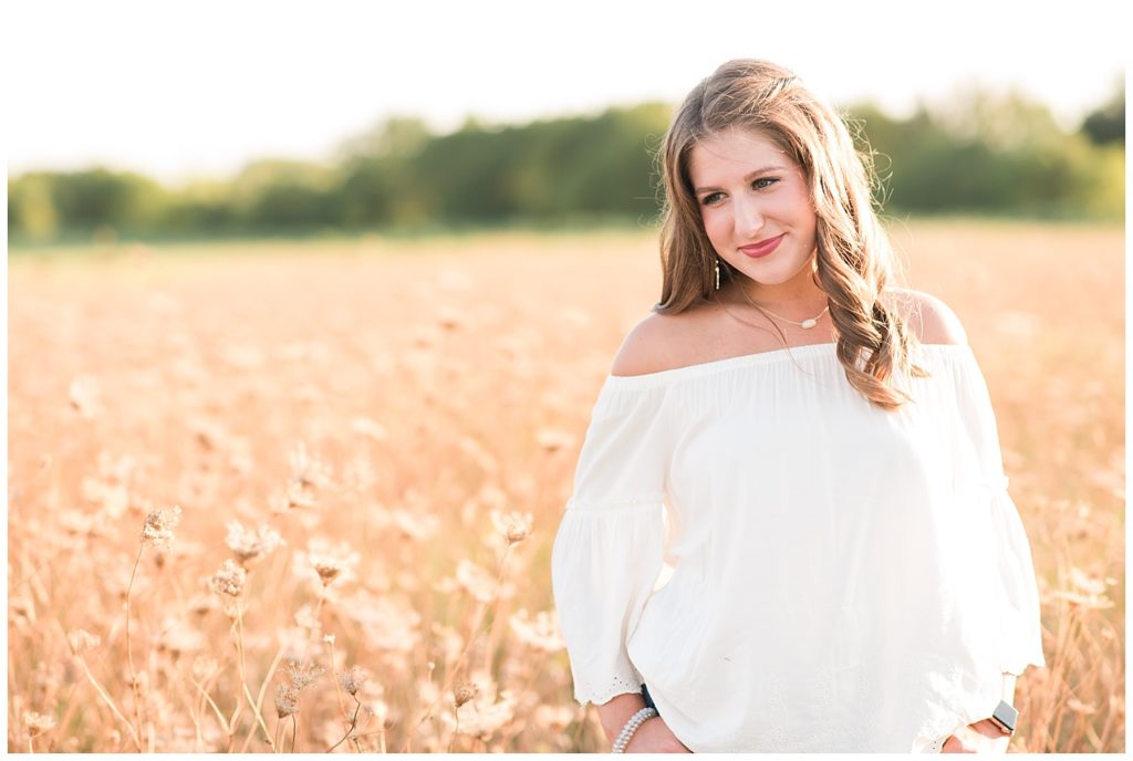 Senior picture of a girl smiling in a field