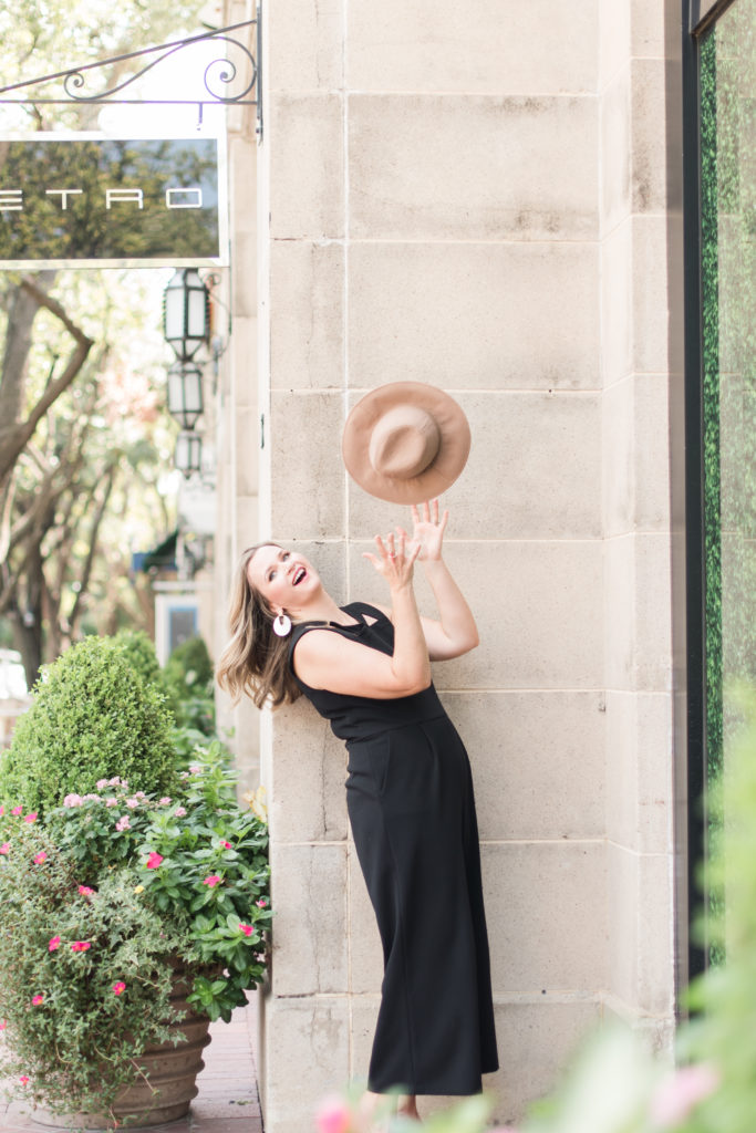 Joyful and fun lifestyle branding images of Dallas woman throwing hat in air at shopping center