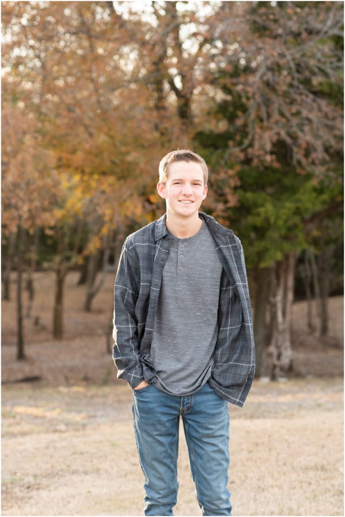 Wylie East senior guy posing for portrait in front of fall foliage