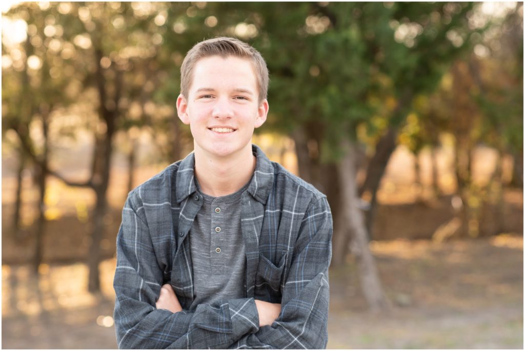 senior guy in plaid shirt with arms crossed for senior portraits