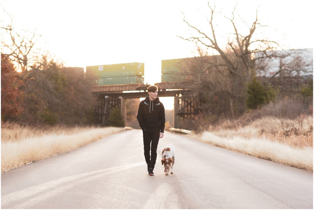 senior guy walking with dog near train tracks in Dallas, TX