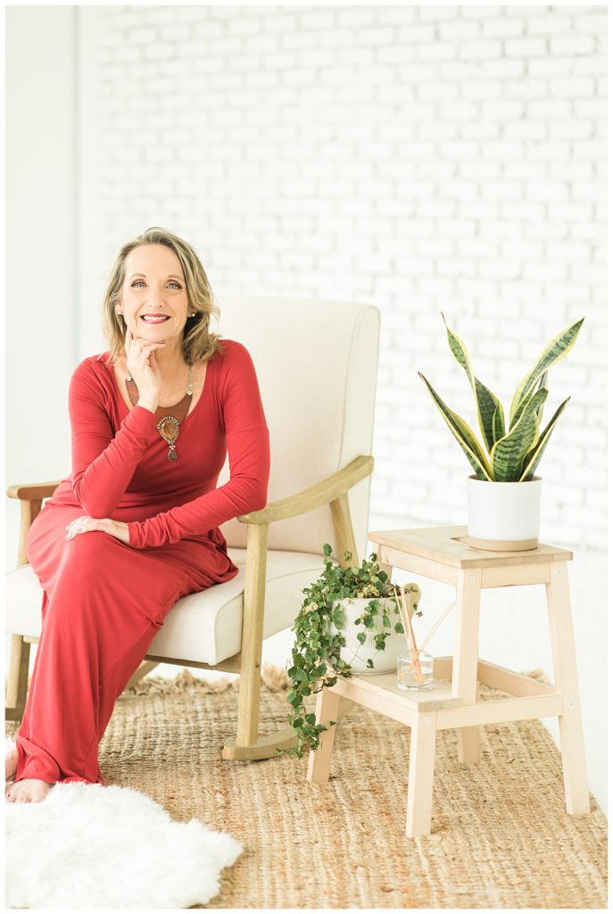 Austin business woman seated in bright dress smiling