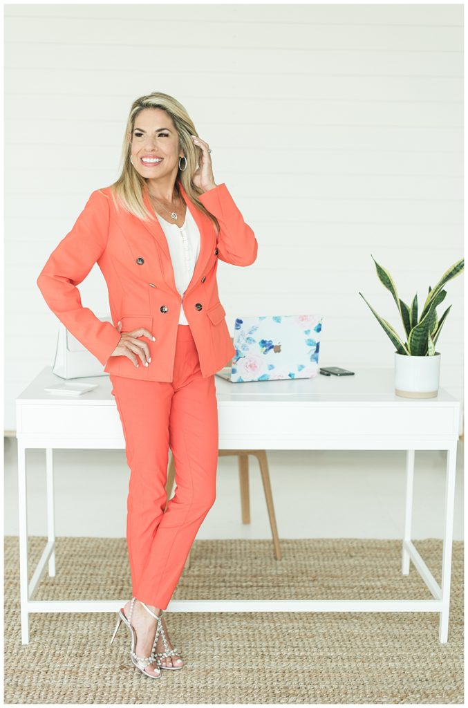 business woman lifestyle branding photo shoot, white desk and orange suit