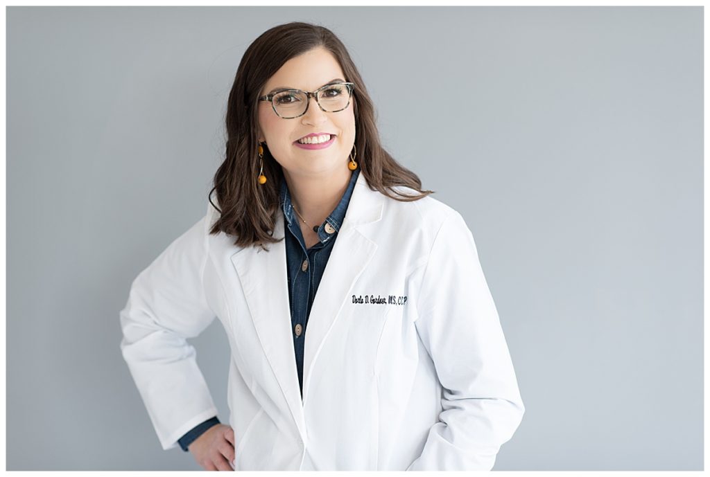 professional woman in white lab coat and glasses