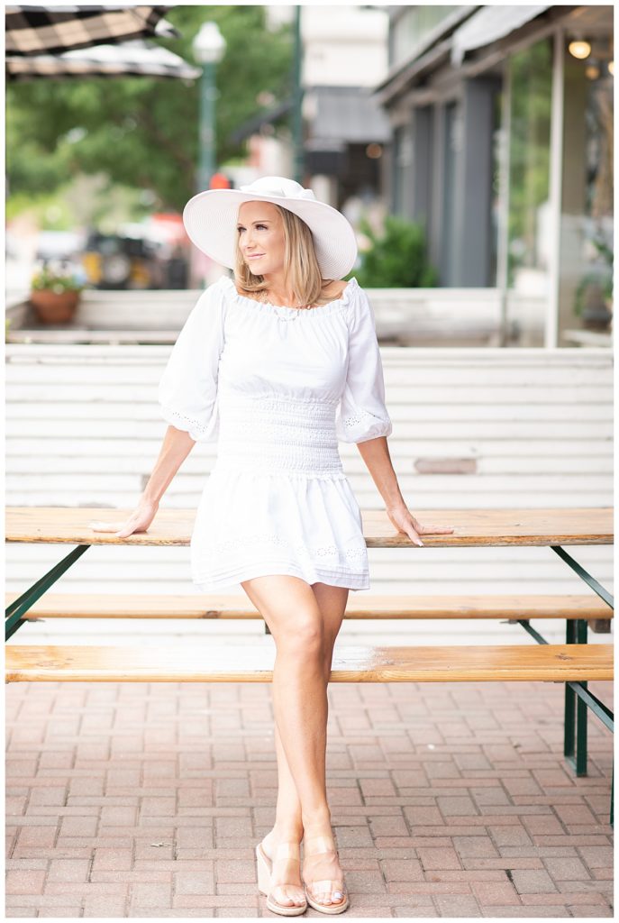 lifestyle image of woman in white dress and hat