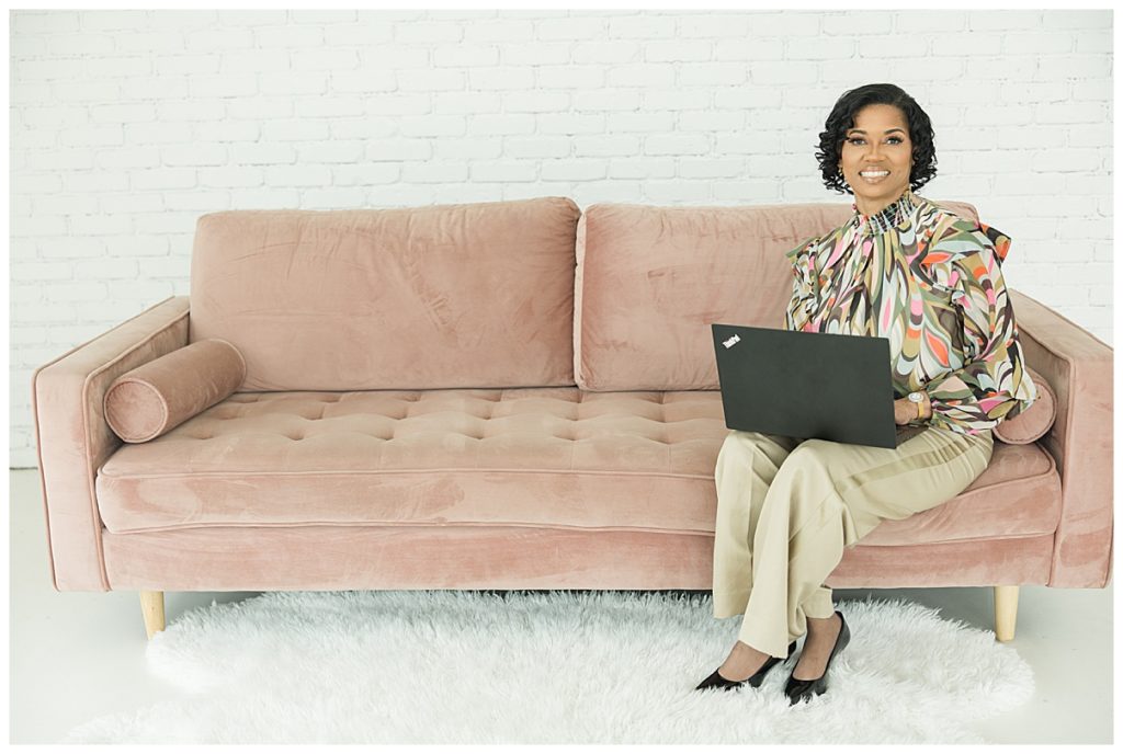 woman on pink couch with laptop